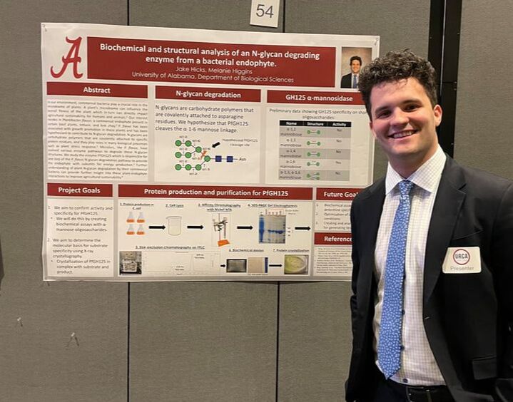 Jake Hicks standing by his research poster.